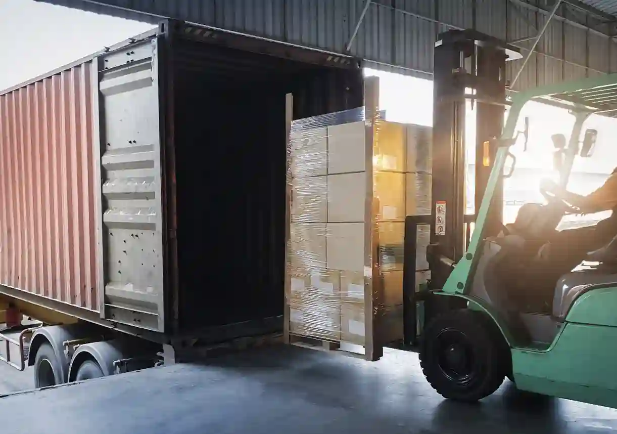 A forklift loading crates into a truck 