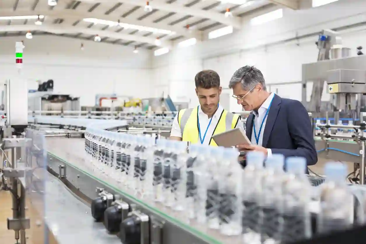 Two gentlemen inspect a factory assembly line 