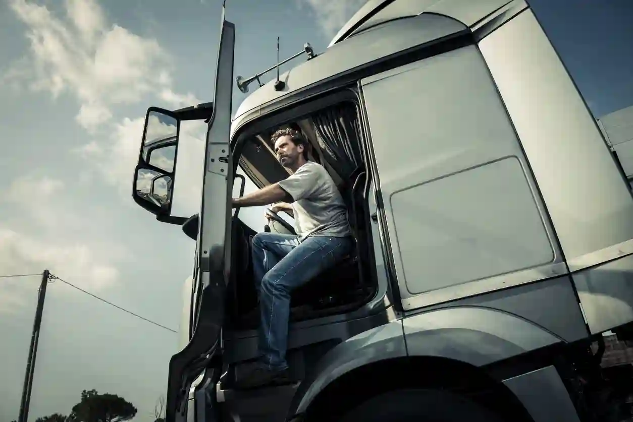 A person opening the cab door of a semi truck