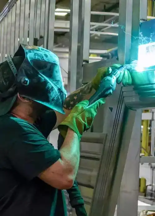 A worker welds the frame of a trailer